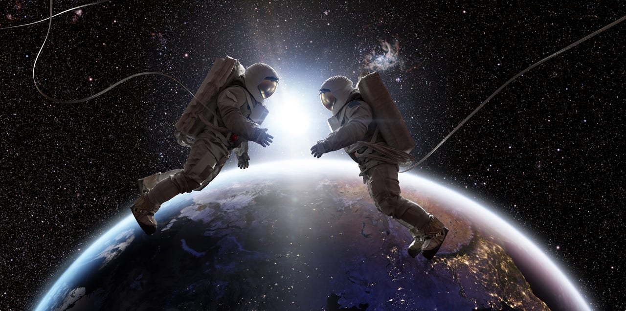 Two astronauts facing eachother in space