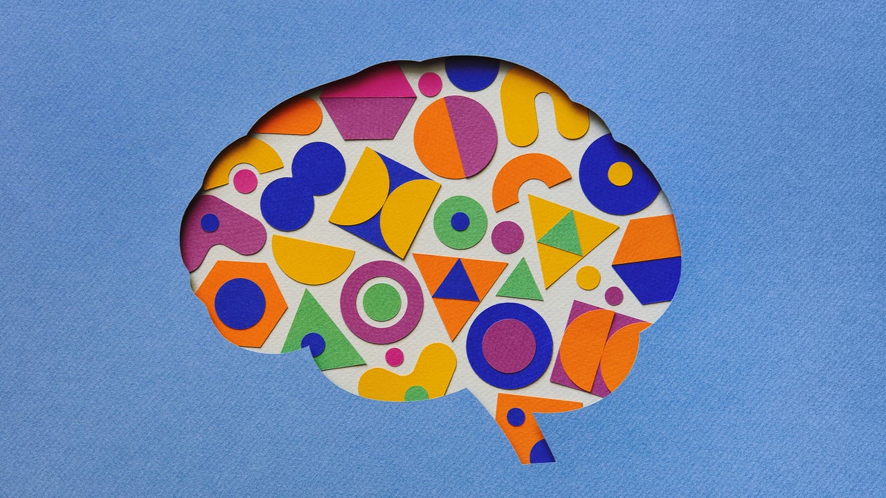 Paper craft illustration of brain filled with multi colored geometric shapes. Creative mind