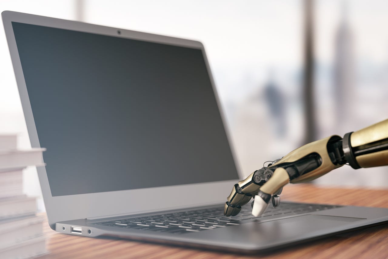 Robot hand typing on a laptop with black screen