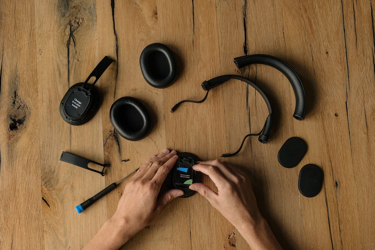 Fairbuds XL headphones taken apart and laid out on a wooden table