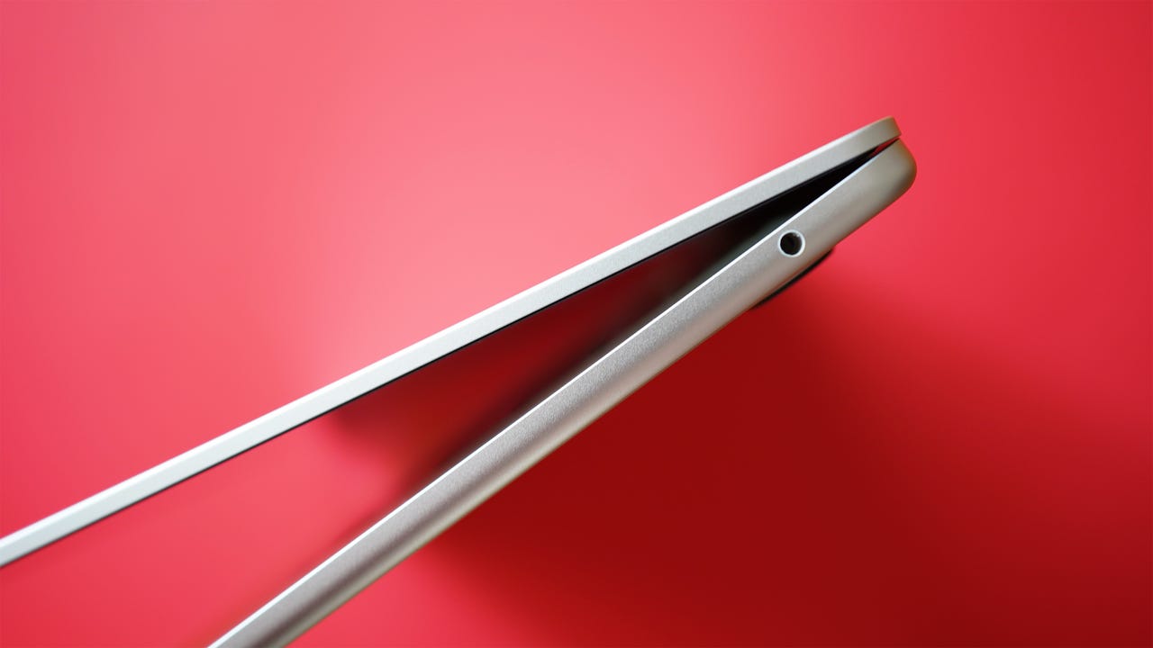 The side of the Apple MacBook Air 15-inch with a red background