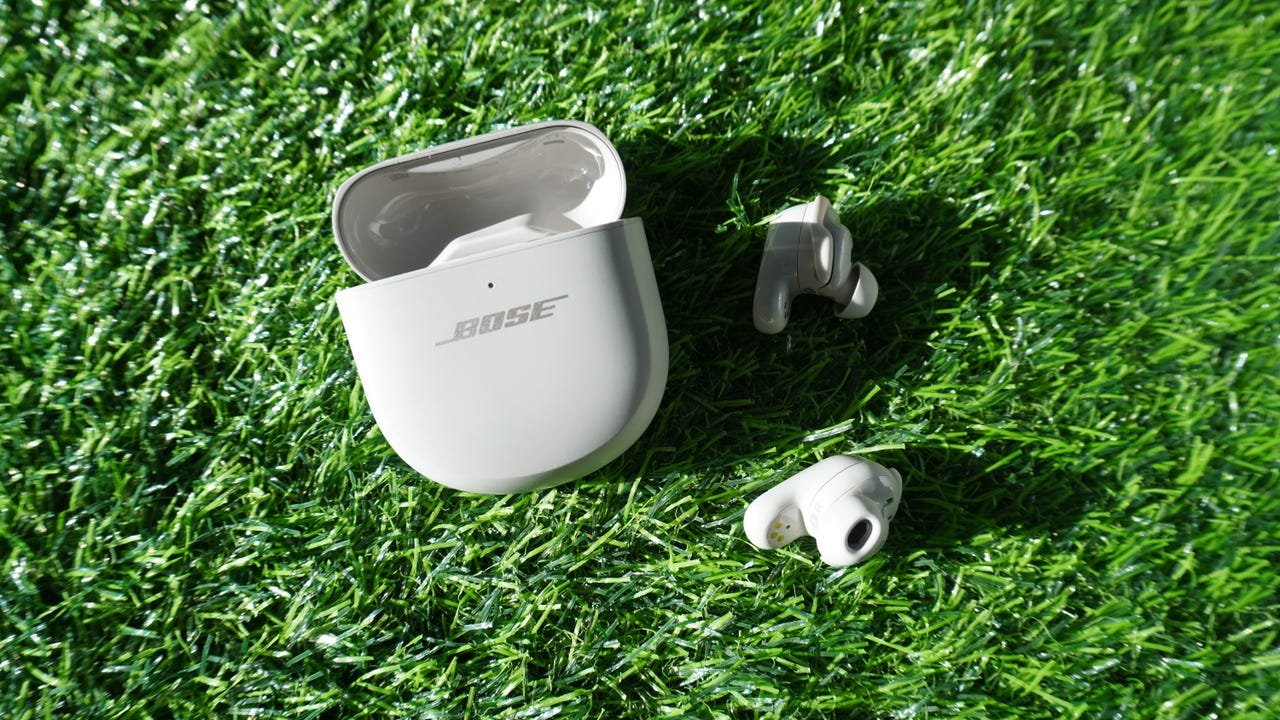 Bose QuietComfort Ultra earbuds against grassy backdrop