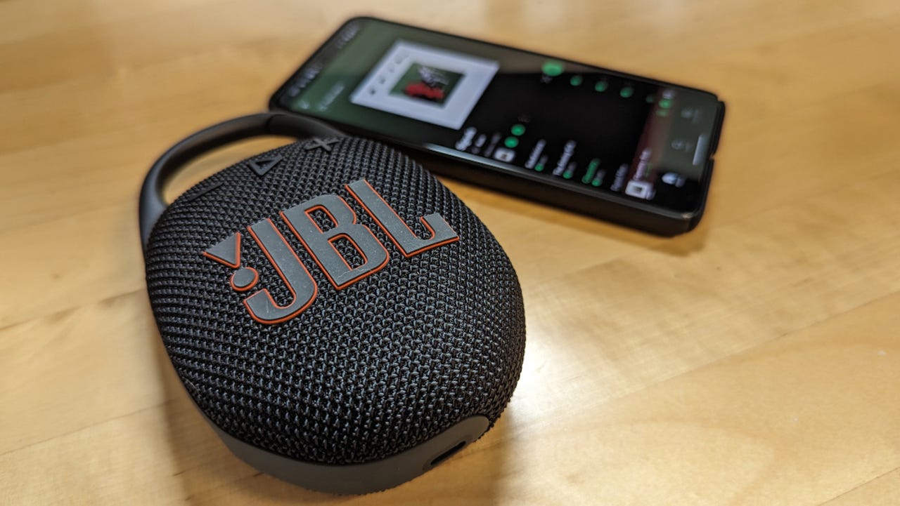 The JBL Clip 5 shown with a Pixel 8 Pro for size comparison.